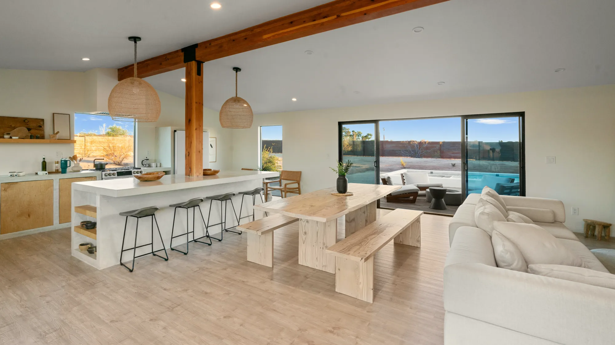 Open-plan kitchen, dining, and living room under a reclaimed timber beam